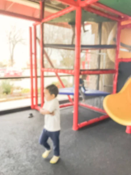 Blurred motion indoor playground with natural lights from glass windows and kids playing