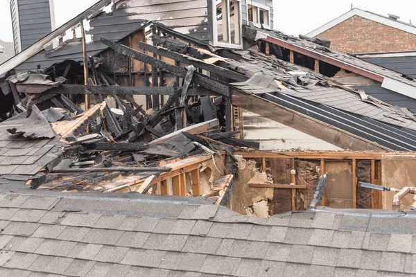 Close-up the roof of damaged apartment after burned by fire in Texas, America. Smoke and dust in burn scene of arson investigation course. Insurance theme of fire devastated