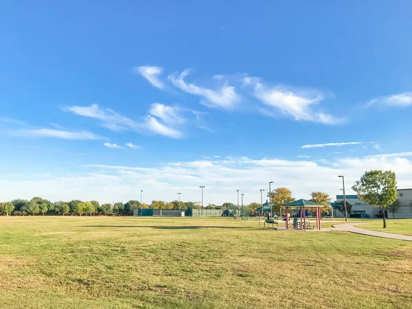 Parque urbano com trilha de concreto e gramado de grama verde ao pôr do sol — Fotografia de Stock