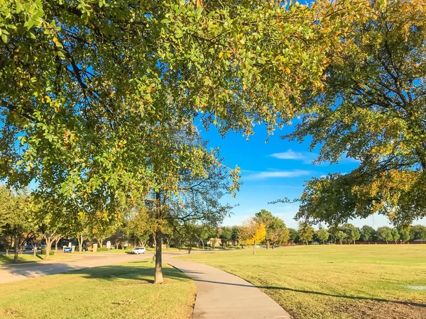 Městský park s konkrétní stopu a zelené trávě trávníku při západu slunce — Stock fotografie
