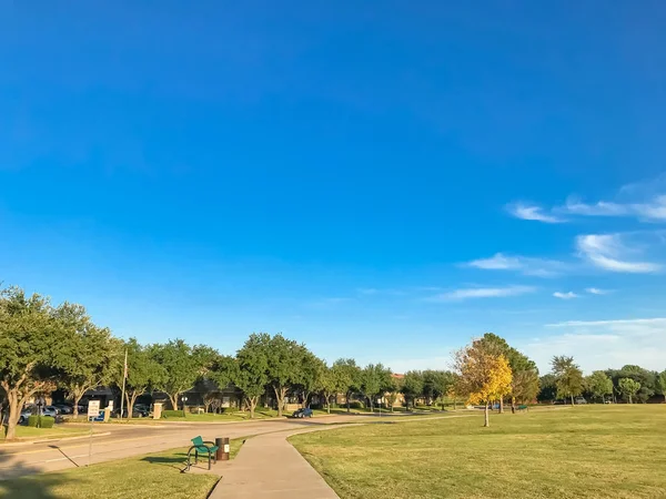 Parque urbano com trilha de concreto e gramado de grama verde ao pôr do sol — Fotografia de Stock