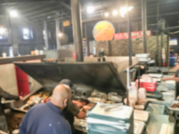 Blurred motion long queue of customer waiting near smoke pit of barbecue restaurant in North Texas, America