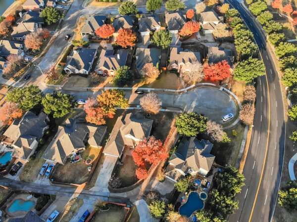 Top view cul-de-sac dead-end street at residential neighborhood near Dallas, Texas. Row of single-family houses surrounded with colorful leaves in autumn season
