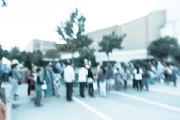 Filtered image blurry background long line of people waiting for — Stock Photo, Image