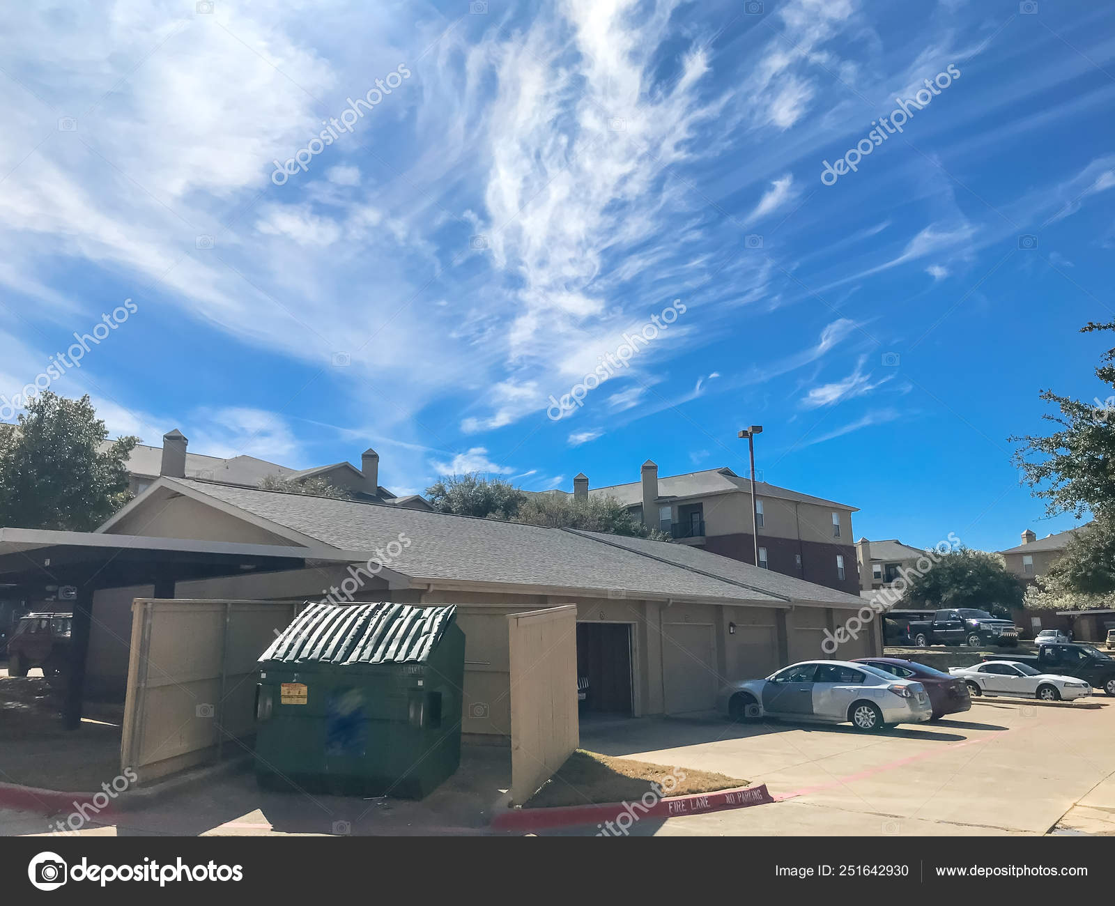 New Apartment Complex With Covered Parking Under Sunny Cloud Sky