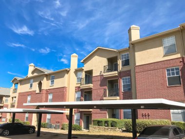Yeni apartman kompleksi ile Teksas güneşli bulut gökyüzü altında kapalı otopark