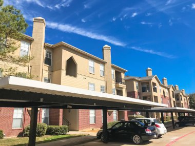 Yeni apartman kompleksi ile Teksas güneşli bulut gökyüzü altında kapalı otopark