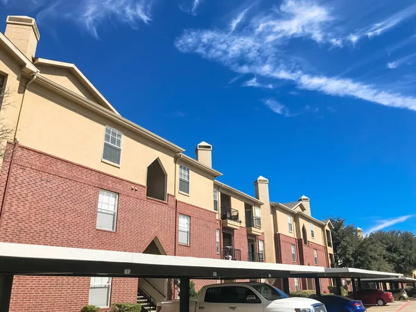 Nuevo complejo de apartamentos con estacionamiento cubierto bajo el soleado cielo nuboso en Texas —  Fotos de Stock