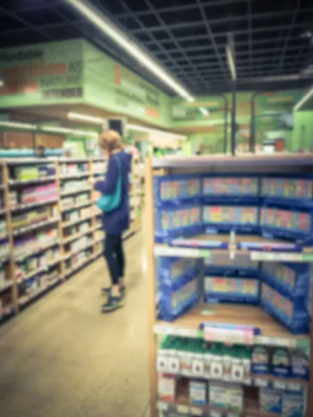 Размытый фон здоровый клиент женщина ищет добавки в аптеке — стоковое фото