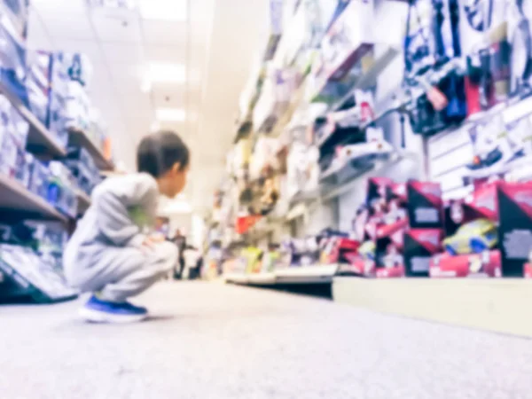 Fundo borrado visão traseira do menino na loja de brinquedos nos EUA — Fotografia de Stock