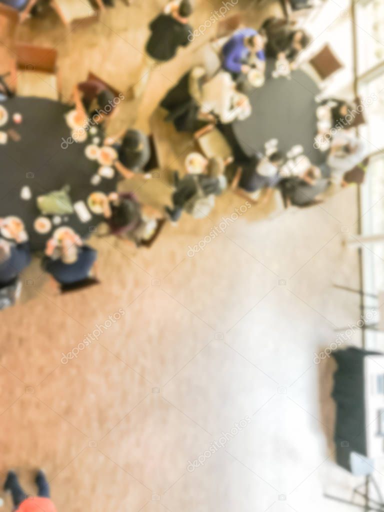 Blurry background crowded people at round banquet table in business event, top view