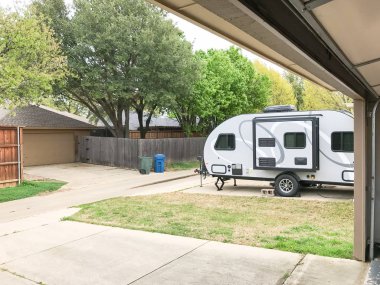 RV trailer parked at backyard of single family house clipart