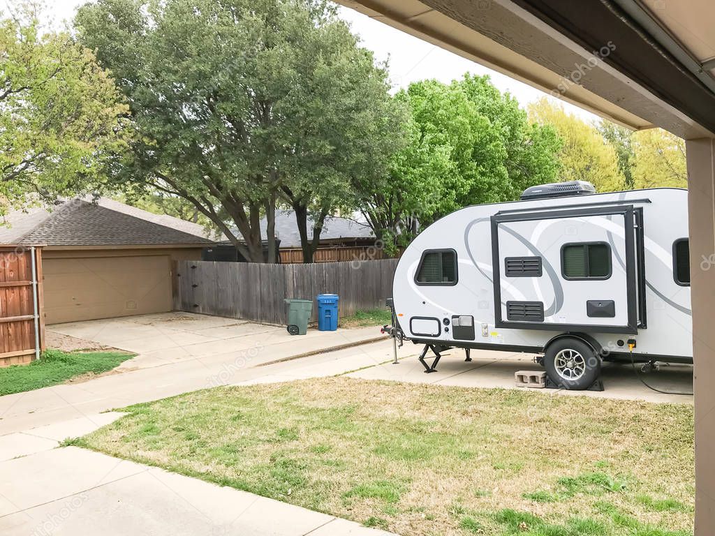 RV trailer parked at backyard of single family house