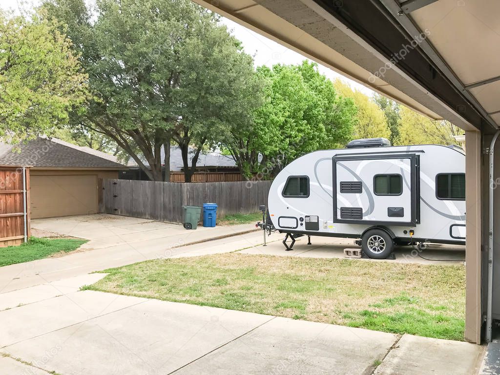 RV trailer parked at backyard of single family house