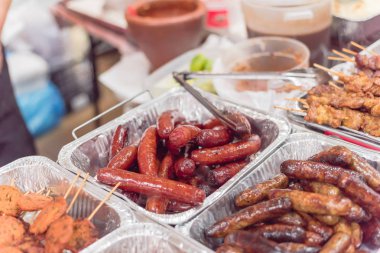 Pazar standında alüminyum folyo durumlarda Satay şişler ve Asya sosis