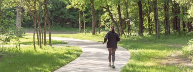 ABD'de parkta yürüyen sağlıklı Beyaz bayanın panoramik arka görünümü