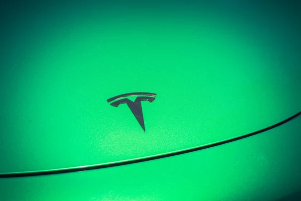 Green car hood cover with Tesla logo close-up — Stock Photo, Image