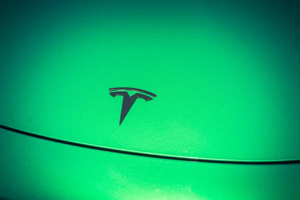 Green car hood cover with Tesla logo close-up — Stock Photo, Image