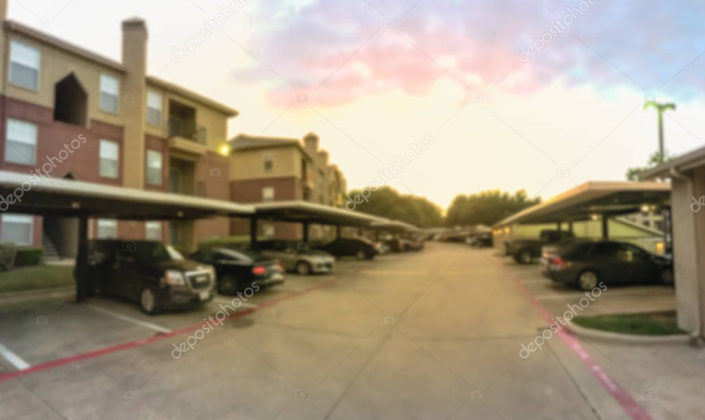 Panoramic blurry background apartment complex with detached garage covered parking lots at sunset