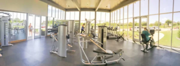 Panoramic blurry background open fitness center with people workout at new home community — Stock Photo, Image