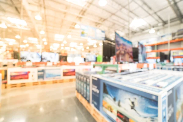 Blurry background row of modern TVs at electronic department of wholesale store