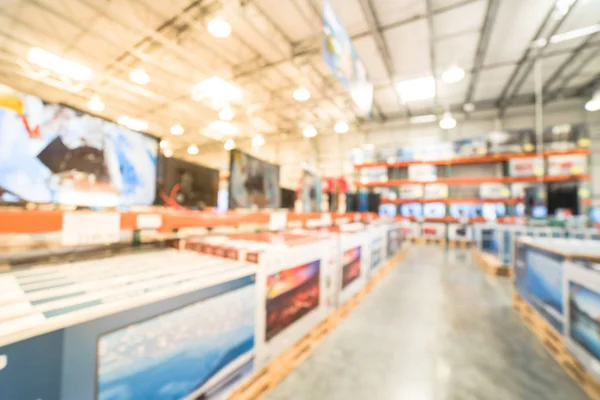 Blurry background row of modern TVs at electronic department of wholesale store