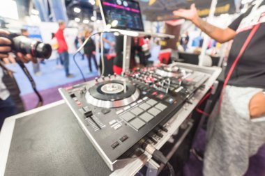 Amerika'daki etkinlik fuarında kulaklık karıştırma müzik giyen Dj bulanık arka plan