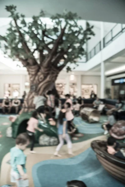 Φιλτραρισμένη εικόνα θολή φόντο ποικίλα παιδιά που παίζουν σε εσωτερική απαλή παιδική χαρά μέσα εμπορικό κέντρο — Φωτογραφία Αρχείου