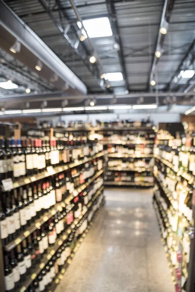 Blurry background variety of wine bottles with price tags at American liquor store