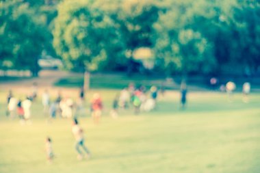 Amerika'da parkta çim çim üzerinde çalışan filtrelenmiş görüntü bulanık arka plan çocuklar