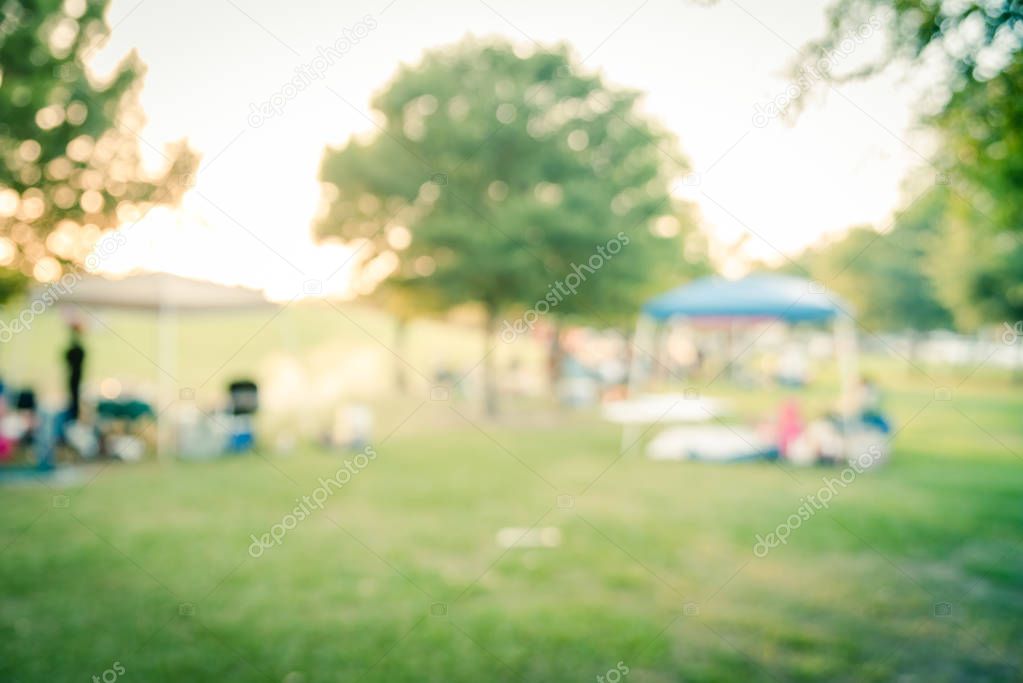 Blurry background people enjoy BBQ and camping in local park at sunset
