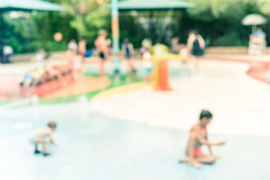 Filtrelenmiş görüntü bulanık arka plan ebeveynler ve çocuklar yaz aylarında su sıçrama ped ilerler