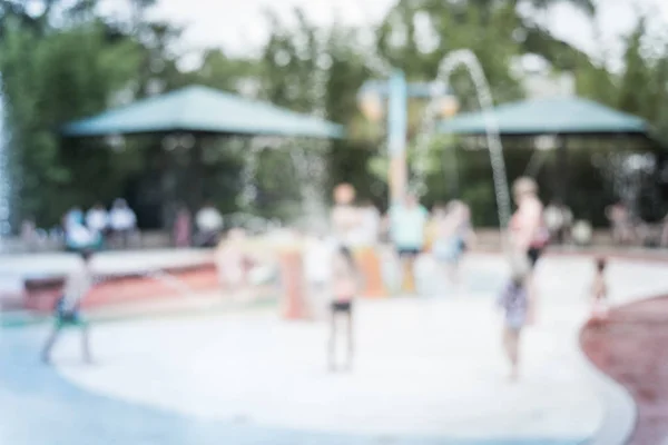 Filtered image blurry background diverse children playing at water splash pad — Stock Photo, Image