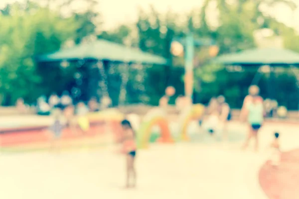 Imagen filtrada fondo borroso diversos niños jugando en la almohadilla de salpicadura de agua —  Fotos de Stock