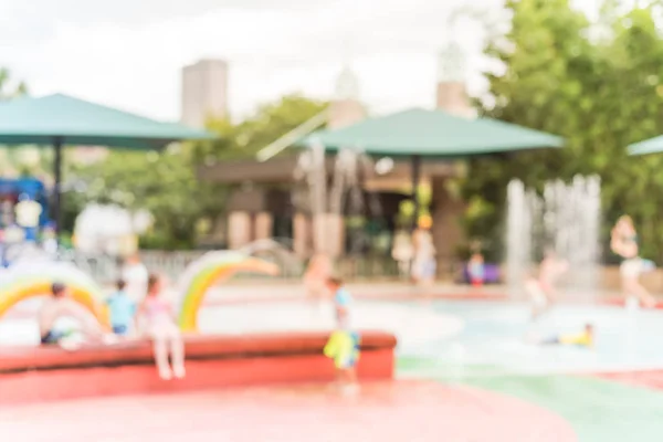 Fondo borroso Los padres y los niños disfrutan de la almohadilla de salpicadura de agua en verano —  Fotos de Stock