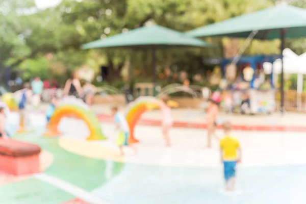 Fondo borroso Los padres y los niños disfrutan de la almohadilla de salpicadura de agua en verano —  Fotos de Stock