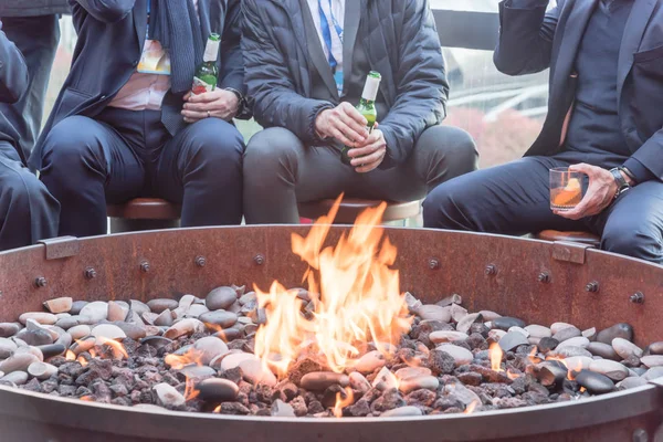 Businesspeople hangout near patio fire pit at wintertime in Chicago, America