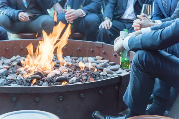 Businesspeople hangout near patio fire pit at wintertime in Chicago, America