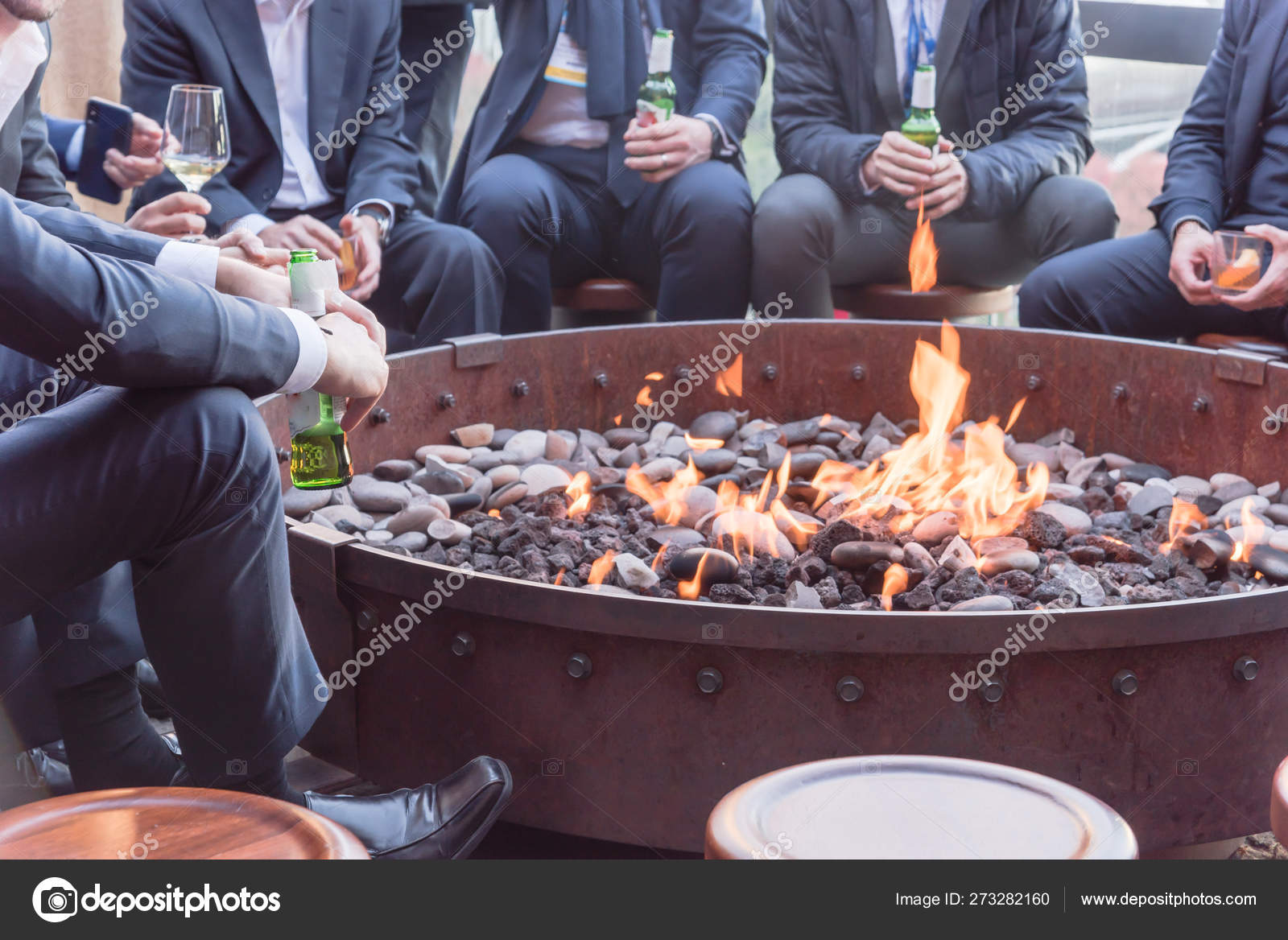Businesspeople Hangout Near Patio Fire Pit At Wintertime In