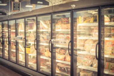 Amerikan süpermarkette dondurucuda bulanık arka plan dondurulmuş pizza