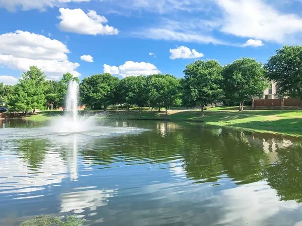 Ставок з відображенням хмар і водного фонтану в маленькому американському околиці — стокове фото