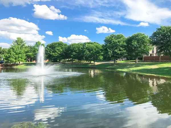 Vijver met wolk reflectie en Waterfontein in kleine Amerikaanse wijk — Stockfoto