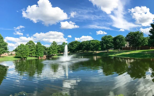 Pond with cloud reflection and water fountain in small American neighborhood — Stock Photo, Image