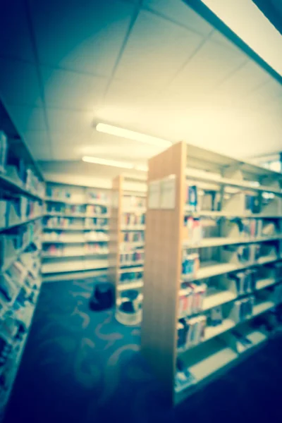 Filtered image blurry background aisle of bookshelf with step stool at public library in USA — Stock Photo, Image