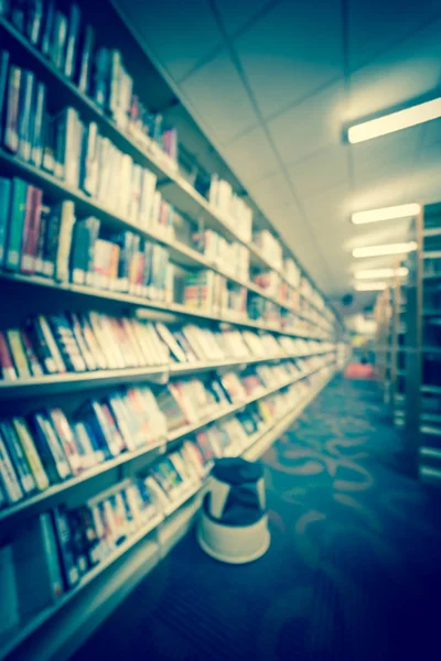 Фильтрованное изображение размытый фоновый проход книжной полки со ступенчатым стулом в публичной библиотеке США — стоковое фото