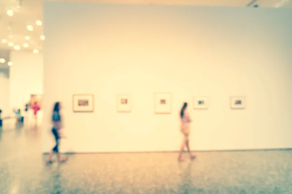 Gente de fondo borrosa mirando exhibición de bellas artes en el museo en América — Foto de Stock