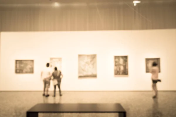 Imagen filtrada borrosa gente de fondo mirando la exhibición de bellas artes en el museo en EE.UU. — Foto de Stock