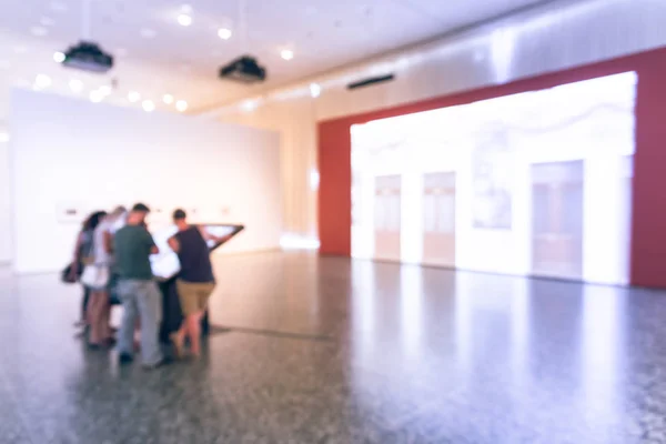 Gente de fondo borrosa mirando exhibición de bellas artes en el museo en América — Foto de Stock