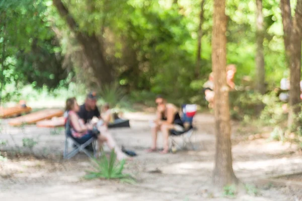 Blurry fondo personas sentadas en sillas de camping plegables al aire libre — Foto de Stock