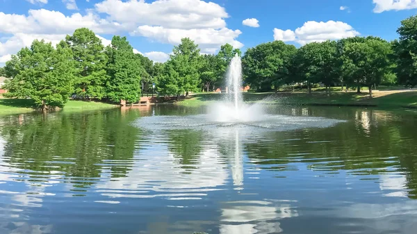 Pond with cloud reflection and water fountain in small American neighborhood — Stock Photo, Image